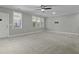 Spacious living room with neutral carpet, ceiling fan, many windows, and a door to the outside at 5554 Colonial Chatsworth Cir, North Charleston, SC 29418