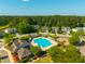 Aerial view of community pool, clubhouse, playground, and surrounding homes nestled among lush trees at 7601 Stargazer Dr, Hanahan, SC 29410