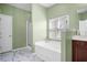 A full bathroom featuring green walls, a tub, shower, and marble-look tile at 7601 Stargazer Dr, Hanahan, SC 29410