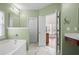 Bathroom featuring green walls, a tub, vanity, and access to the bedroom at 7601 Stargazer Dr, Hanahan, SC 29410