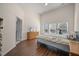 Bright bedroom featuring wood floors, a large window, TV, and ensuite bathroom at 7601 Stargazer Dr, Hanahan, SC 29410