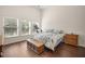 This spacious bedroom features wood floors and large windows for ample natural light at 7601 Stargazer Dr, Hanahan, SC 29410