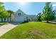Well-kept home featuring a lush green lawn, a two-car garage, and vibrant landscaping under a clear blue sky at 7601 Stargazer Dr, Hanahan, SC 29410