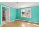 Bright bedroom with turquoise walls and hardwood floors, featuring a window for natural light and ventilation at 813 W 1St North St, Summerville, SC 29483