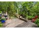 Picturesque view of a pond from a wooden deck surrounded by lush greenery and flowering plants at 815 W Carolina Rd, McClellanville, SC 29458