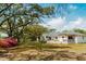 Spacious backyard with mature trees, a covered patio, and lush green lawn, perfect for outdoor gatherings at 847 Condon Dr, James Island, SC 29412