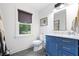Charming bathroom with a blue vanity, marble countertop, dark framed window, and geometric floors at 847 Condon Dr, James Island, SC 29412