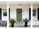 Charming home entrance with a green door, black shutters, and decorative potted ferns at 847 Condon Dr, James Island, SC 29412