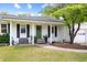 Inviting home exterior featuring a white brick facade, green door, and well-manicured lawn at 847 Condon Dr, James Island, SC 29412