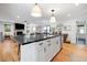 Open-concept kitchen with an island and seating, hardwood floors, and stainless steel appliances at 847 Condon Dr, James Island, SC 29412