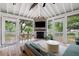 Cozy screened patio with a ceiling fan, fireplace, and comfortable seating area at 847 Condon Dr, James Island, SC 29412