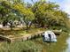 Lush waterfront property with a private dock and a boat offers an idyllic setting with gorgeous trees at 847 Condon Dr, James Island, SC 29412