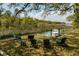 A charming waterfront area with lush trees, a fire pit, seating, and a boat provides a tranquil escape at 847 Condon Dr, James Island, SC 29412