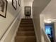 Carpeted staircase with white railing and decorative wall art at 8634 Grassy Oak Trl, North Charleston, SC 29420