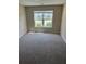 Bright, carpeted bedroom with a large window and neutral walls, creating a cozy and inviting space at 9032 Maple Grove Dr, Summerville, SC 29485