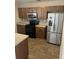 Cozy kitchen featuring wooden cabinets, stainless steel appliances, and a dark tile backsplash at 9032 Maple Grove Dr, Summerville, SC 29485