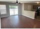 An open concept living room with hardwood floors, featuring a ceiling fan and sliding glass doors at 9032 Maple Grove Dr, Summerville, SC 29485