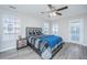 Bedroom with a ceiling fan, light gray walls, wood flooring, and a bed with blue accent blanket at 9042 Parlor Dr, Ladson, SC 29456