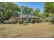 Charming brick home with a well-manicured front yard, mature trees, and a welcoming red front door at 1012 Cliffwood Dr, Mount Pleasant, SC 29464