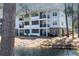 Three-story condo building with balconies overlooking a pond and lush greenery at 1025 Riverland Woods Pl # 906, Charleston, SC 29412