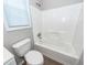 Bathroom featuring a shower over tub with white tile surround, vinyl flooring, and a window for natural light at 119 Carolina Wren Ave, Ladson, SC 29456