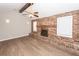 This living room features a brick fireplace, ceiling fan and wood-look flooring at 119 Carolina Wren Ave, Ladson, SC 29456