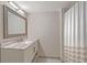 Bathroom featuring large mirror, marble countertop, white sink, and a shower with tan and white striped curtain at 14 Lockwood Dr # 11H, Charleston, SC 29401