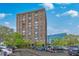 A large condo building is surrounded by trees and parked cars under a blue sky with scattered clouds at 14 Lockwood Dr # 11H, Charleston, SC 29401