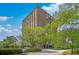 A tall, brick condo building set among lush trees and greenery, with a clear blue sky as the backdrop at 14 Lockwood Dr # 11H, Charleston, SC 29401