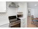 Well-equipped kitchen with stainless steel range, modern hood, white cabinets, and eat-in dining area view at 14 Lockwood Dr # 2D, Charleston, SC 29401
