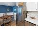 Modern kitchen with stainless steel appliances, stylish backsplash, dining area, and sleek white cabinets at 14 Lockwood Dr # 2D, Charleston, SC 29401