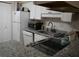 Efficient kitchen with white cabinets, granite countertops, and modern appliances at 141 Marsh View Villas, Folly Beach, SC 29439