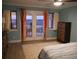 Bright primary bedroom featuring balcony access, wood tile floors, and beachy decor at 141 Marsh View Villas, Folly Beach, SC 29439