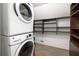 This laundry room includes front load washer and dryer, and dark wood open shelving at 1516 Village Sq, Mount Pleasant, SC 29464