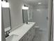 Bright bathroom featuring dual sink vanity, quartz countertop, and walk-in shower with glass door at 1527 S Pinebark Ln, Charleston, SC 29407