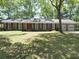 Charming brick ranch home with a well-manicured lawn and mature trees at 1527 S Pinebark Ln, Charleston, SC 29407