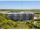 Stunning aerial view of a modern condo building with a pool, surrounded by lush greenery and a beautiful waterfront at 155 Wingo Way # 415, Mount Pleasant, SC 29464