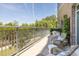 View of the condo's long balcony featuring wicker seating and a view of mature trees at 155 Wingo Way # 415, Mount Pleasant, SC 29464