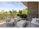 Outdoor balcony with cozy seating, brick facade, and a view of lush greenery and blue skies at 155 Wingo Way # 415, Mount Pleasant, SC 29464