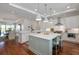 Open-concept kitchen featuring white cabinets, a large island with seating, stainless steel appliances and wood floors at 155 Wingo Way # 415, Mount Pleasant, SC 29464