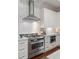 Modern kitchen with stainless steel range, custom hood, white subway tile backsplash, and plenty of storage at 155 Wingo Way # 415, Mount Pleasant, SC 29464