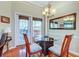 Cozy dining area with a glass table, three chairs, and a chandelier for warm lighting at 1832 Telfair Way # 1832, Charleston, SC 29412