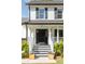 Close-up of a beautiful white brick home with a stately black front door and porch at 193 Corn Planters St, Charleston, SC 29492