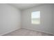 Simple bedroom with neutral carpet, white walls, a window, and electrical outlets at 202 W Bradford Pointe Drive Dr, Summerville, SC 29483