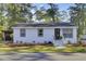 Charming white brick home with manicured front yard landscaping and easy access to parking at 210 Peters St, Summerville, SC 29483