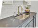 Granite countertop with stainless steel sink, tile backsplash, and updated fixtures at 210 Peters St, Summerville, SC 29483