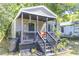 Home's entry showing a cozy porch, landscaping, and a view of the surrounding greenery at 2125 Victory Ave, North Charleston, SC 29405