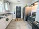 Galley style kitchen with white cabinets, stainless appliances, and dark entry door at 2125 Victory Ave, North Charleston, SC 29405