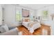 Bright bedroom with hardwood floors, large windows, and a cozy bed with neutral-toned decor at 22 Frogmore Rd, Mount Pleasant, SC 29464