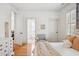Comfortable bedroom with hardwood floors, a cozy armchair, and a view into an en-suite bathroom at 22 Frogmore Rd, Mount Pleasant, SC 29464